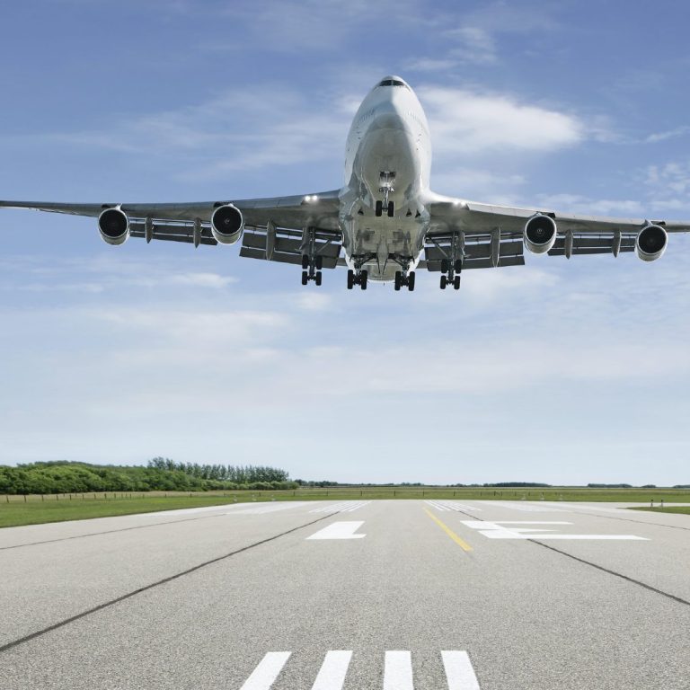 Charter this B747-100F for your next cargo A large airplane is taking off from a runway under a clear blue sky.